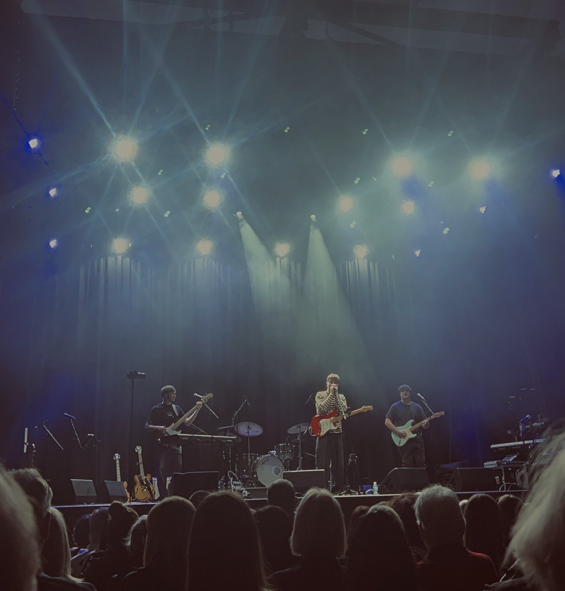 George performing live on stage with a band